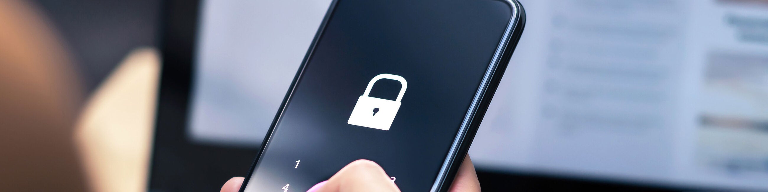 photo of a hand holding a phone displaying a lock icon