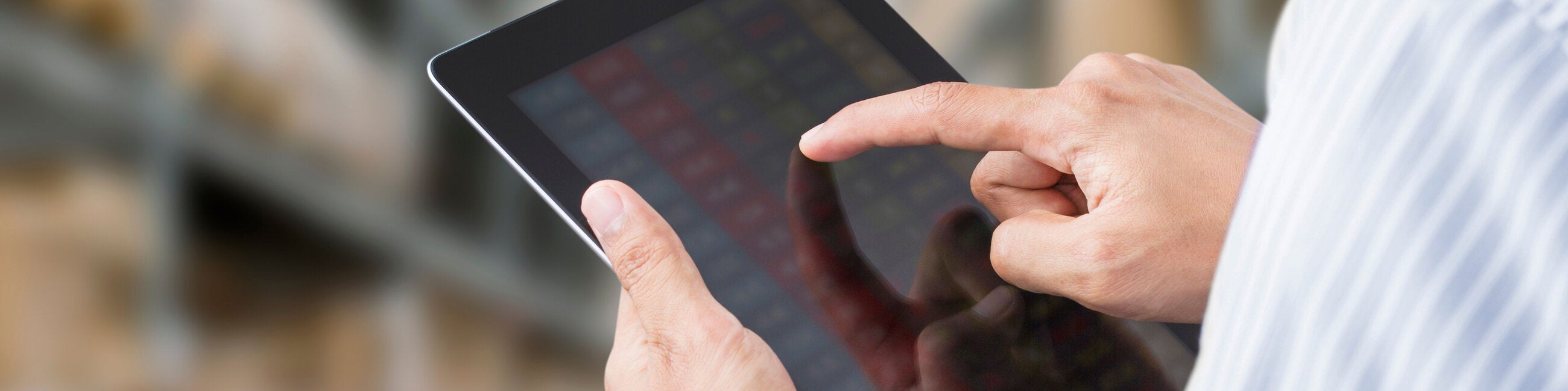 Close up of a man working on a tablet.